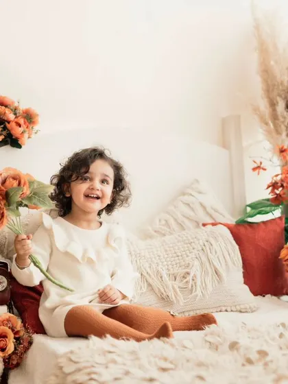 A cozy, autumn-themed setup for a toddler. The warm colors, soft textures, and floral arrangements create a beautiful and inviting scene.