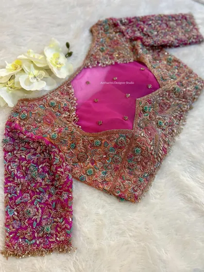 The back of the orange and pink blouse, featuring a sheer panel and dense embroidery.
