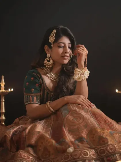 Lost in thought, our model showcases the quiet elegance of this traditional lehenga. The diyas in the background add to the classic, festive mood.