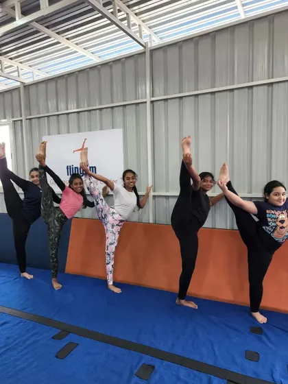 Our gymnasts line up to show off their standing splits, a skill that requires significant hamstring flexibility and balance, which we develop through consistent practice.