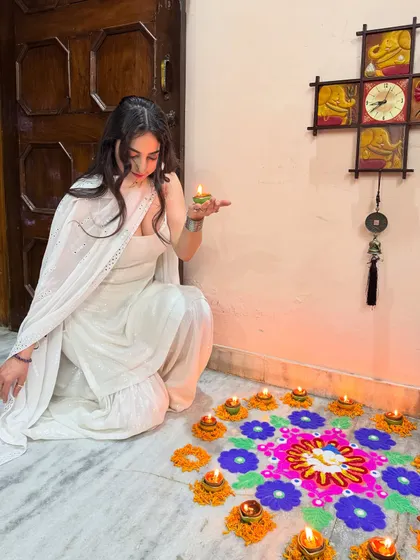 Holding a diya, surrounded by the warm glow of Diwali. This photo captures the peace and happiness of the festival of lights.