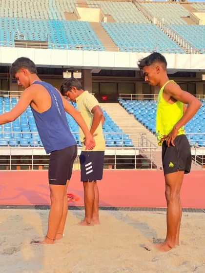 Partner-assisted stretching in the sand pit after a tough workout. This helps improve flexibility and aids in muscle recovery, an essential part of our cool-down routine.