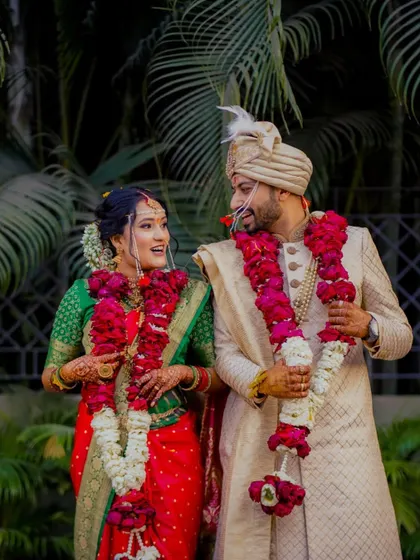 A playful moment during the varmala ceremony, as the groom teases his bride with the garland. A fun, candid shot full of laughter.