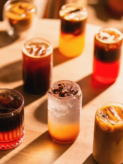 An assortment of iced coffees and specialty cold brews. We use lighting to emphasize the different colors and layers in each drink, showcasing the variety on offer.