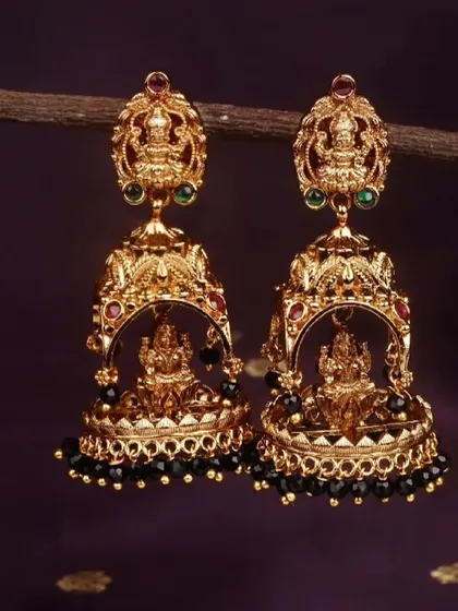 A close-up of the traditional Lakshmi jhumkis with black beads. This is a classic and versatile option that pairs well with many different saree colors.