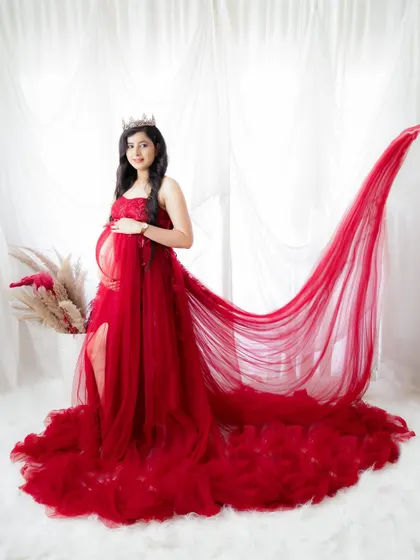 A stunning portrait of a queenly mom-to-be. Her red gown with a long, dramatic train creates a powerful and unforgettable image.
