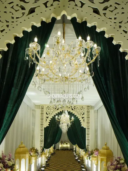 A grand entrance sets the tone for an exceptional event. For this evening gala, we created a stunning entryway with lush green velvet drapes, intricate laser-cut arches, and magnificent crystal chandeliers to welcome guests into a world of elegance.
