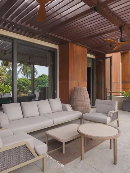 This spacious deck is one of several private retreats designed for different family units within the home. The pergola provides shade, creating a comfortable indoor-outdoor living experience.