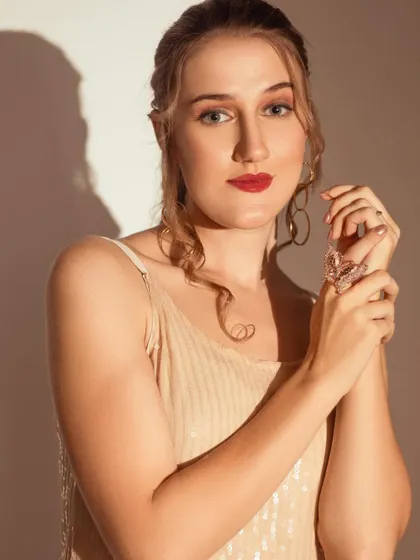A direct and engaging portrait using the same dramatic lighting. The contrast between light and shadow highlights the model's features.