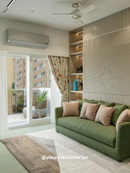 Here, a pop of color from the green sofa brings life to a neutral space. The fluted wall paneling and built-in shelving add architectural interest and provide a stylish solution for storage and display.