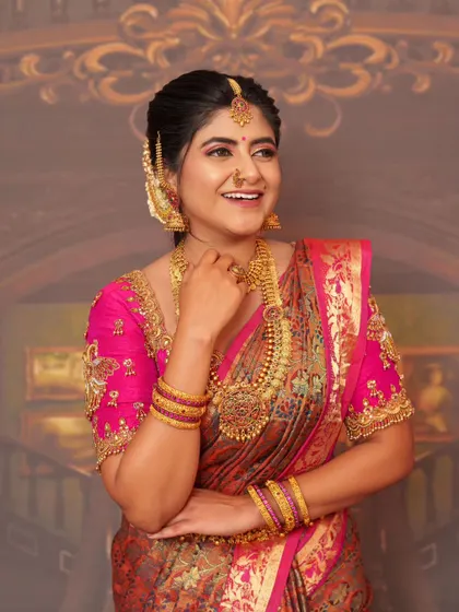 A happy and radiant look in a pink silk saree with heavy jewelry.