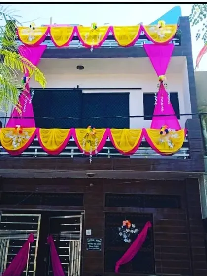 Balcony decoration with yellow and pink drapes in a simple, festive pattern.