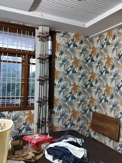 A bedroom with a colorful tropical leaf wallpaper. The mix of orange, blue, and green leaves adds a vibrant and energetic feel to the space.