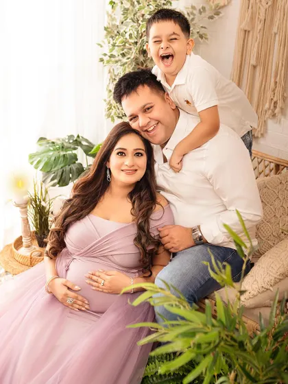 A candid moment of pure family joy. Including older siblings in maternity shoots makes them feel special and captures the excitement of the growing family.
