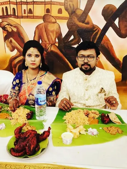 A couple enjoying their meal against a backdrop of traditional art.