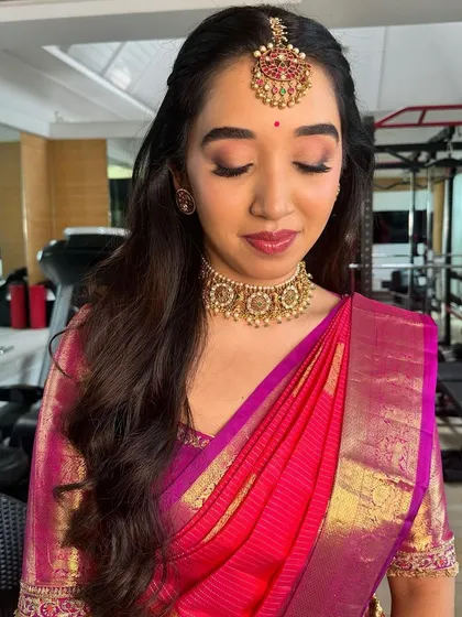 A festive look for Ganesh Pooja, featuring a bright pink silk saree and traditional gold jewelry.