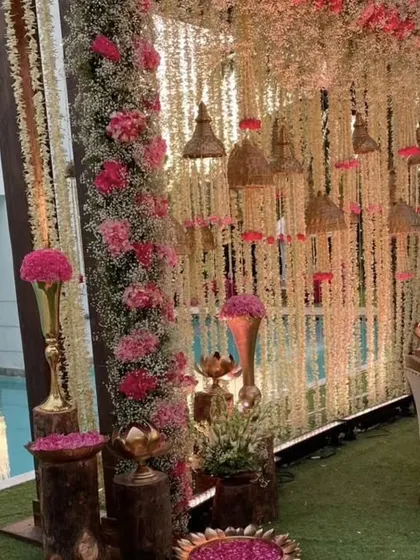 This poolside wedding decor combines rustic charm with floral elegance. We used hanging floral strings, dramatic pink arrangements, and wooden pedestals to transform the space.
