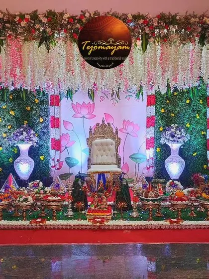 A baby shower setup with a lotus-themed backdrop and hanging floral arrangements, creating a beautiful and symbolic setting.