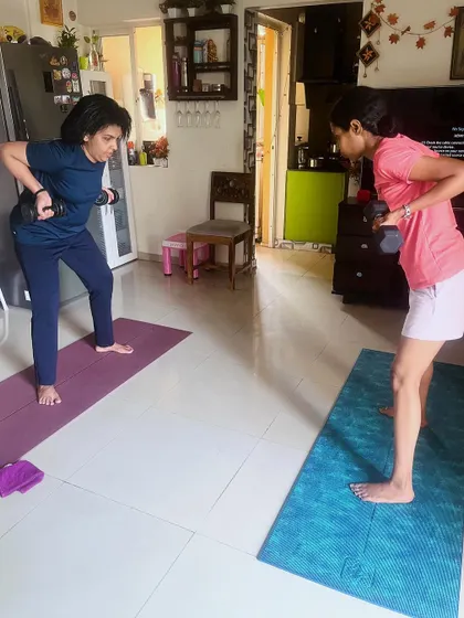 Two clients perform bent-over dumbbell rows, a key exercise for strengthening the back and improving posture. Notice their flat backs and engaged cores, a result of consistent coaching on form.