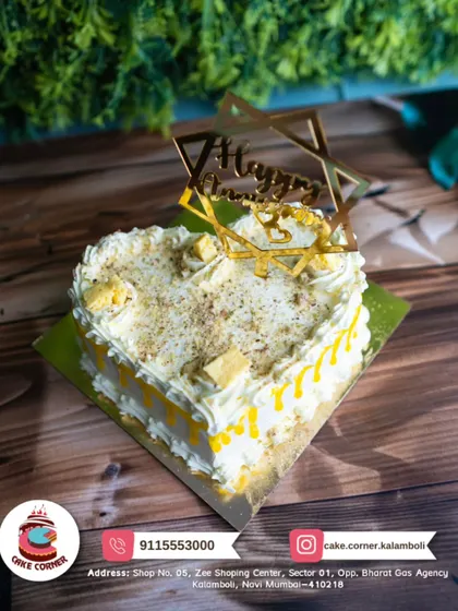 A beautiful heart-shaped anniversary cake with a golden topper. The yellow and white design is bright and cheerful, perfect for a happy celebration.