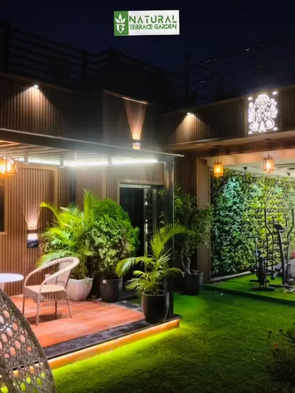 A view of the Model Town terrace, showing the dedicated outdoor gym area with a vertical garden backdrop, seamlessly integrated with the lounge space.
