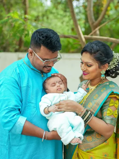 A lovely family portrait from a naming ceremony, with both parents lovingly looking at their new baby.