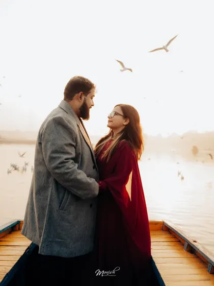 A beautiful portrait on a boat with birds flying overhead, creating a magical and serene atmosphere for their pre-wedding shoot.