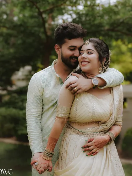 A warm embrace between a couple in a lush garden setting, showcasing their love and happiness during their engagement shoot.