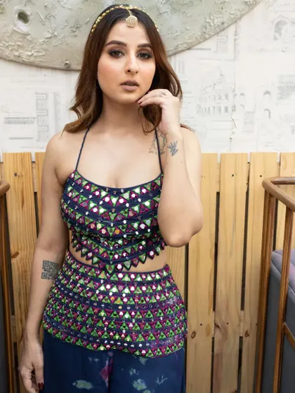 A confident pose, showing off her tattoos and her cool, ethnic style.
