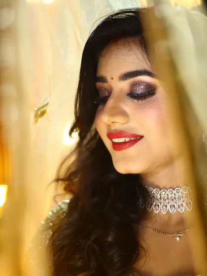 A stunning reception look. The glittery smokey eye and bold red lip are perfect for a night of celebration.