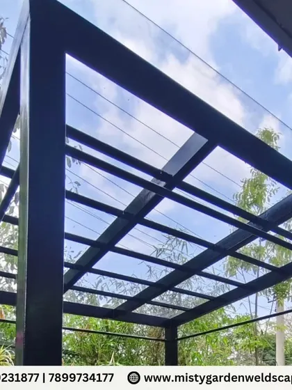 Another perspective of the sleek, black-framed compact sheet pergola. The clean lines and transparent roof make the structure feel light and unobtrusive, blending seamlessly with the garden.