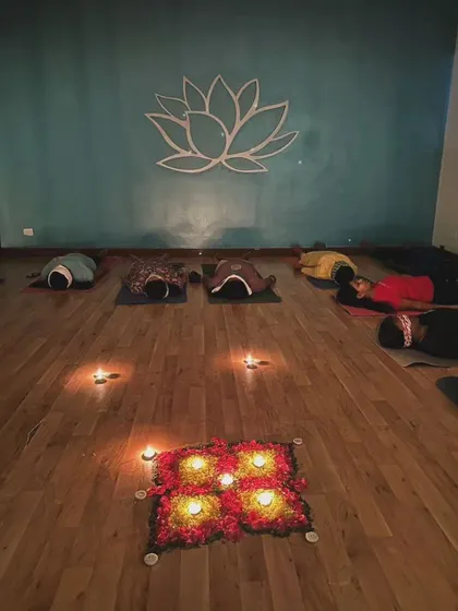 Participants resting peacefully around a flower and candle mandala. This beautiful centerpiece adds to the sacred and intentional atmosphere of our sound healing ceremonies.