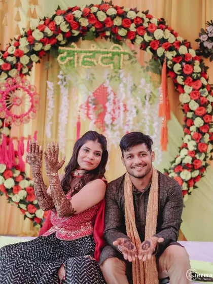 The couple proudly shows off their Mehendi designs to the camera. A classic and happy shot from the pre-wedding celebrations.