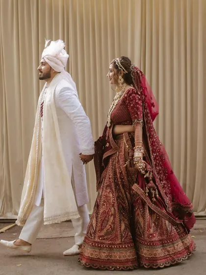 Walking together, hand in hand. A candid, full-length shot that captures the elegance and movement of the couple on their wedding day.