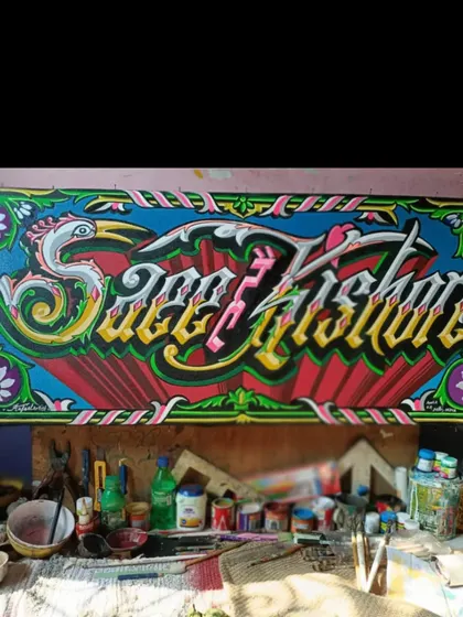 A custom nameplate, "Saeef Kishore," painted in an ornate, flowing script and surrounded by floral and bird motifs, seen here in my workshop.
