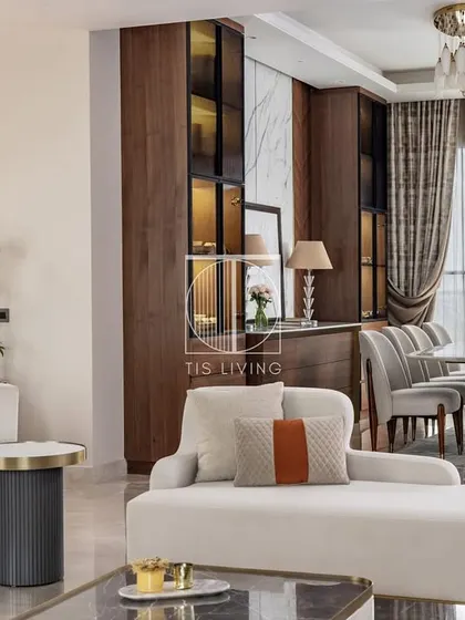 This living and dining area is a study in modern luxury. We crafted the curved white sofa with brass accents, the matching chaise, and the elegant dining set to create a seamless and sophisticated open-plan living space.