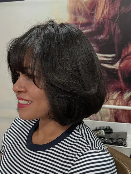 A layered bob with bangs for Anupama, giving her a soft and voluminous look.