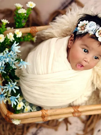 A simple, clean setup with a pop of color from the flowers. This baby's alert expression and tiny tongue peeking out show a glimpse of the personality that is already there.