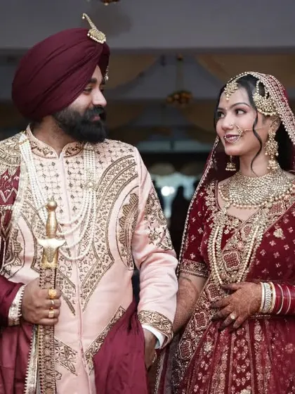 The couple captured during their walk, the groom holding a kirpan, showcasing a traditional element of a Sikh wedding.