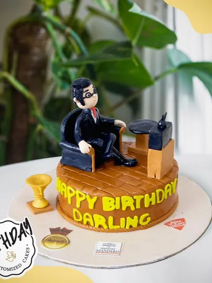 A special cake for a husband, featuring a fondant figure relaxing in his favorite armchair. A sweet and personal way to celebrate his birthday.