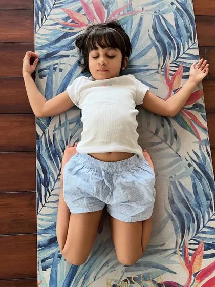 Even our youngest students can find deep rest. This little girl is in Supta Virasana, a pose that stretches the thighs and ankles.