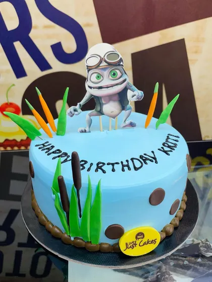 A fun 2kg Crazy Frog theme cake, bringing the nostalgic character to life in a pond setting.