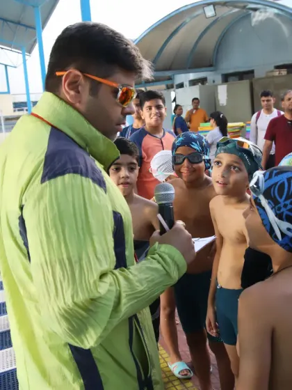 Briefing a group of young swimmers before their race. My goal is to create a supportive environment where they can feel confident and ready.