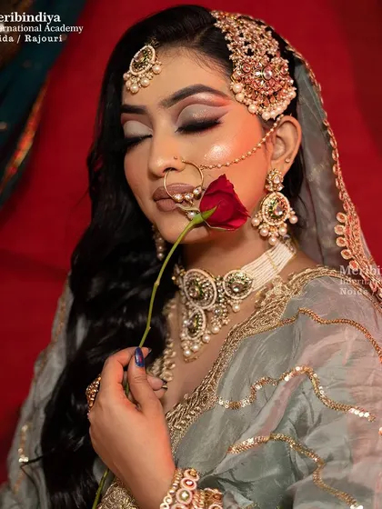 A Pakistani bridal look featuring a stunning side 'jhoomar' and 'maang tikka' set against soft, open hair.