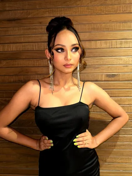 A full-body shot of the model in a classic black dress, showing how a dramatic smokey eye can elevate a simple outfit into a stunning evening look.