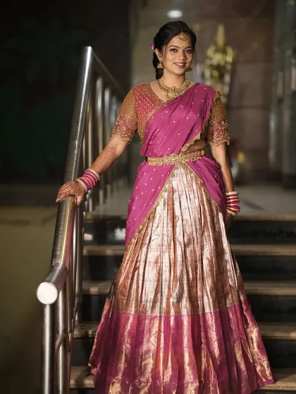 Teju looking radiant on the stairs at her engagement. Her half-saree and traditional makeup create a beautiful, classic look.