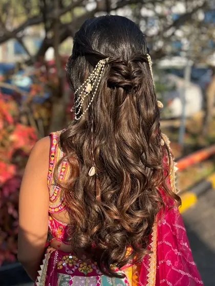 A view of the beautiful, intricate hairstyle with pearl and shell details, perfect for a beachy or daytime event.
