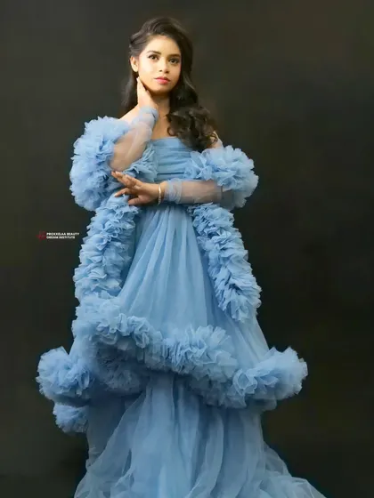 Feeling fierce in this stunning blue ruffled gown. The makeup is kept soft and pretty to balance the drama of the dress, creating a look worthy of a fairytale ball.