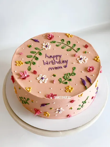 Doodling on a cake can be so beautiful! This red velvet cake with cream cheese frosting has a hand-piped floral and leaf design, perfect for a mom's birthday.