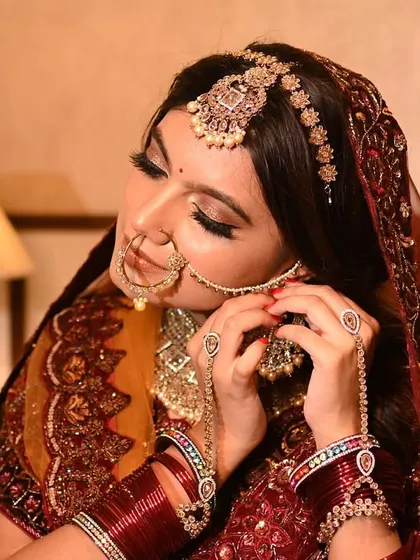 A beautiful candid moment of the bride adjusting her nath. These small, elegant gestures make for timeless bridal portraits.